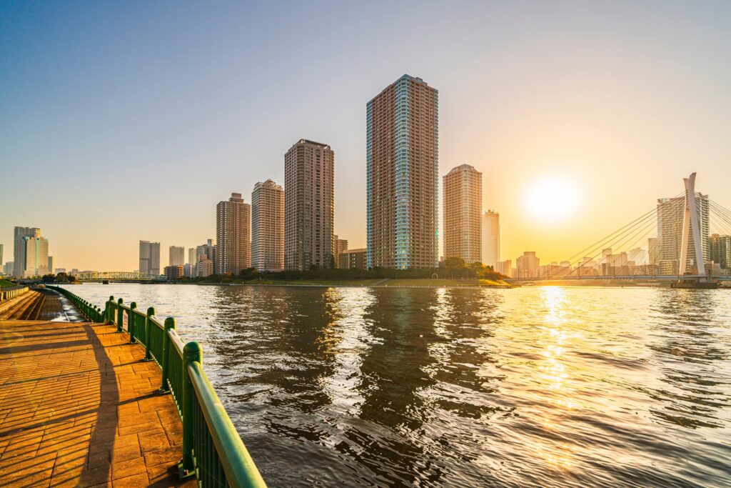 Sunset view of the Sumida River lined with skyscrapers on a bridge in tokyo