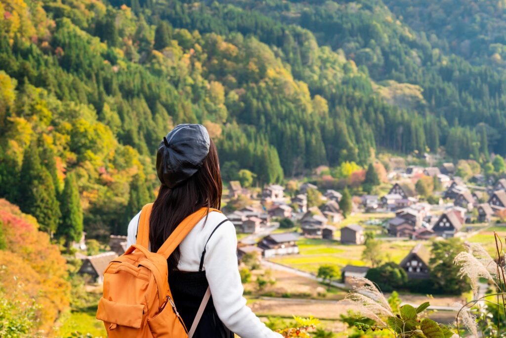 woman admiring colorful foliage at shirakawa-go in autumn